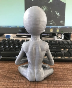 Back view detail of 3D printed resin alien figurine in meditating pose for garden decor