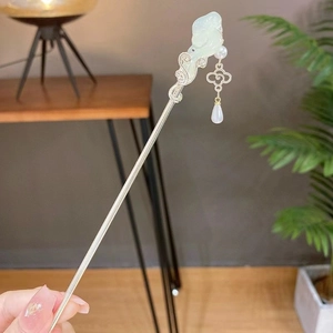 Detail of silver hair stick with green jade magnolia flower and pearl tassels