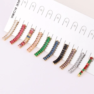 Macro detail of baguette-cut colorful crystal earrings with curved zircon settings