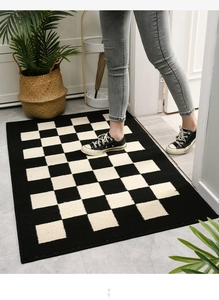 Close-up of black and white checkered entryway rug featuring durable woven texture