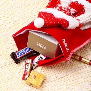 Detail shot of a large red knit Christmas stocking filled with candies on a lace cloth