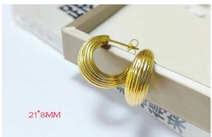 Macro shot of 18K gold plated stainless steel teardrop hoop earrings with texture