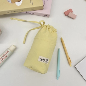 Detail of yellow fabric drawstring pouch with cute cartoon dog and stationery