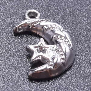 Macro shot of silver moon and star pendant with textured details and a top ring