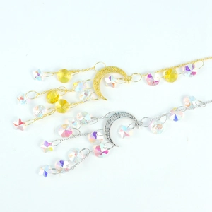Detailed view of gold and silver suncatcher pendants with crescent moon and crystal beads