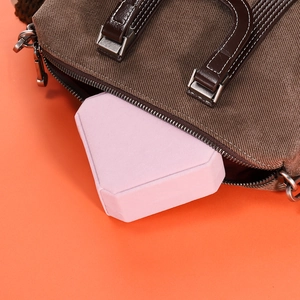 Pink velvet geometric jewelry box shown inside a brown canvas bag for travel
