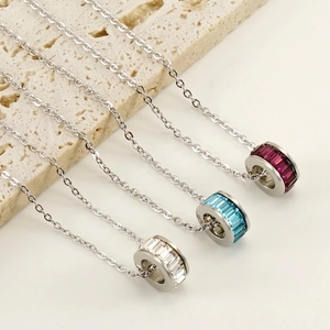 Three-color stainless steel pendant necklaces with square-cut gems on travertine stone