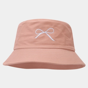 Close-up of pink coral bucket hat with white bow embroidery and high-quality cotton texture