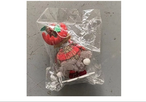 Detailed view of a reindeer Christmas gnome plush with red plaid fabric and grey fur accents