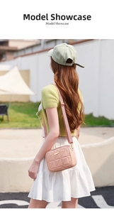 Outdoor model showcase of a pink quilted camera bag with adjustable wide strap crossbody