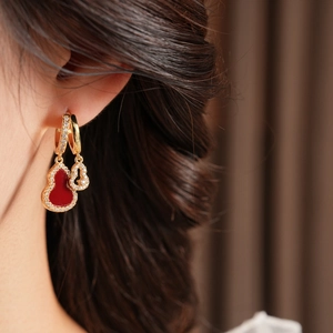Detailed close-up of hollow gourd earrings with red zircon and sparkling accents