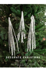 Close-up of elegant white pearl bead sprays hanging on a festive Christmas tree with lights