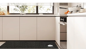 Detail of grey waterproof kitchen mat with cute cartoon logo on modern floor