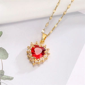 Macro shot of heart-shaped red ruby pendant with gold chain and white zircon inlay