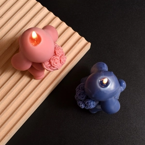 Artistic rabbit holding flower bouquet candles in pink and blue for home decor