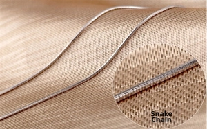 Close-up of polished silver snake chain necklace showing detailed metallic link structure
