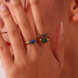 Close-up of gold-plated stainless steel rings with blue and green oval natural stones