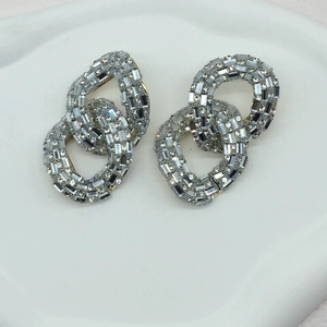 Macro detail of silver oversized chain link earrings with micro-paved crystal rhinestones