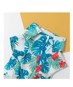 Close-up of hawaiian pet shirt featuring blue monstera leaves and red hibiscus flowers