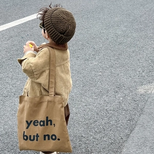 Primer plano de un niño con un gorro de lana marrón y una chaqueta de pana a juego