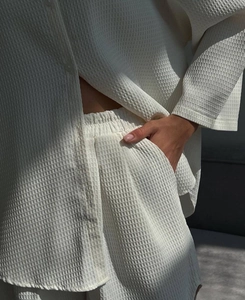 Detailed macro view of white waffle knit texture and button closure on loungewear set