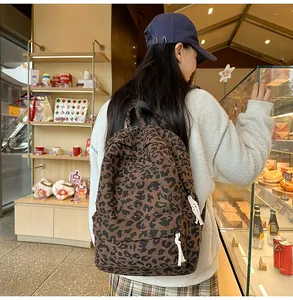 Street style leopard print corduroy backpack for women shown in a cozy cafe setting