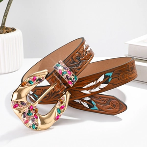 Close-up of brown leather belt with floral engraving and colorful rhinestone buckle