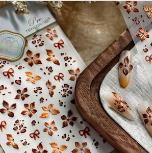 Detailansicht von Vintage-Nagelaufklebern mit Leoparden- und Blumenmuster auf Holztablett