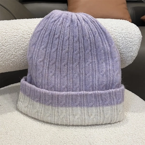 Detail of chunky knit texture in purple and cream beige winter beanies