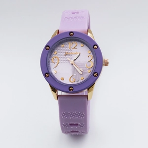 Detail of quartz watch featuring purple silicone strap and gold case with heart indices
