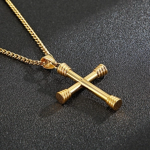 Detailed close-up of golden stainless steel cross pendant with textured ends on Cuban chain