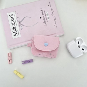 Detailed view of pink fabric earphone case with blue heart and silver star charms
