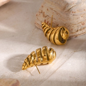 Macro shot of 18K gold plated hollow teardrop earrings on a natural stone base