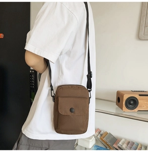Side view of dark brown canvas messenger bag with adjustable strap and front flap pocket