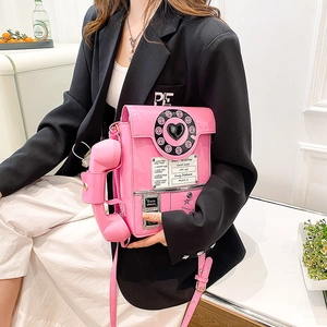 Detail of pink retro telephone crossbody bag with rotary dial and handset accessory