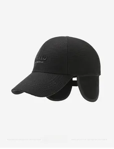 Detail view of winter baseball cap featuring plaid texture, ear flaps and Paris embroidery