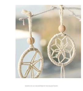 Detail of handcrafted bohemian wall hanging with cotton rope, wooden beads, and feathers
