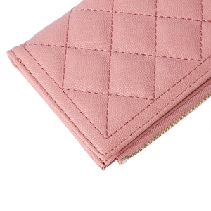 Detail of pink quilted PU leather wallet featuring a gold zipper and grain texture