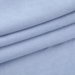 Detailed macro view of light blue polo jacket fabric with fine texture and soft folds