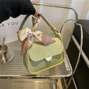 Green faux leather crossbody bag with chain strap and decorative silk scarf handle