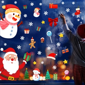 Detailed view of Santa and snowman static stickers being applied to a window glass