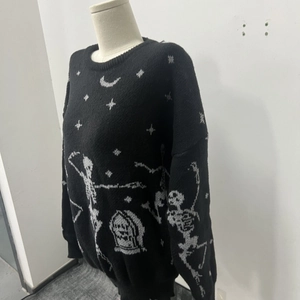 Detail of black Halloween knit sweater featuring gray skull and moon jacquard patterns