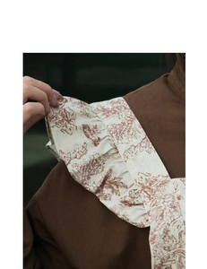 Close-up of vintage floral cotton apron featuring French toile de Jouy ruffles