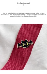 Macro view of cute black enamel cat bat pin with yellow eyes on canvas background