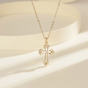 Detail of a golden S925 sterling silver Celtic knot necklace with a zircon cross pendant