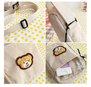 Detail view of corduroy bear bag showing adjustable strap, embroidery and inner capacity