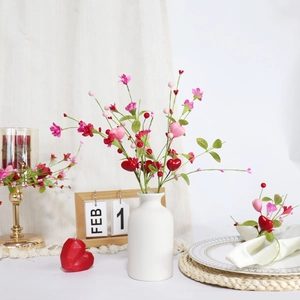 Artificial heart-shaped flower bouquet in a white ceramic vase for Valentines decor