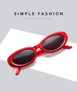 Vue détaillée des lunettes de soleil ovales en résine rouge avec accents métalliques