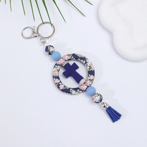 Detail of blue silicone cross keychain with floral beads and a decorative tassel