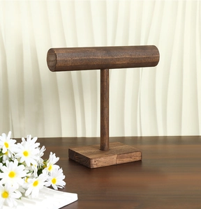 Detail of vintage dark wood T-bar jewelry stand with natural wood grain for bracelets
